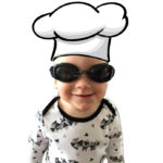 a child wearing a cook's hat and glasses