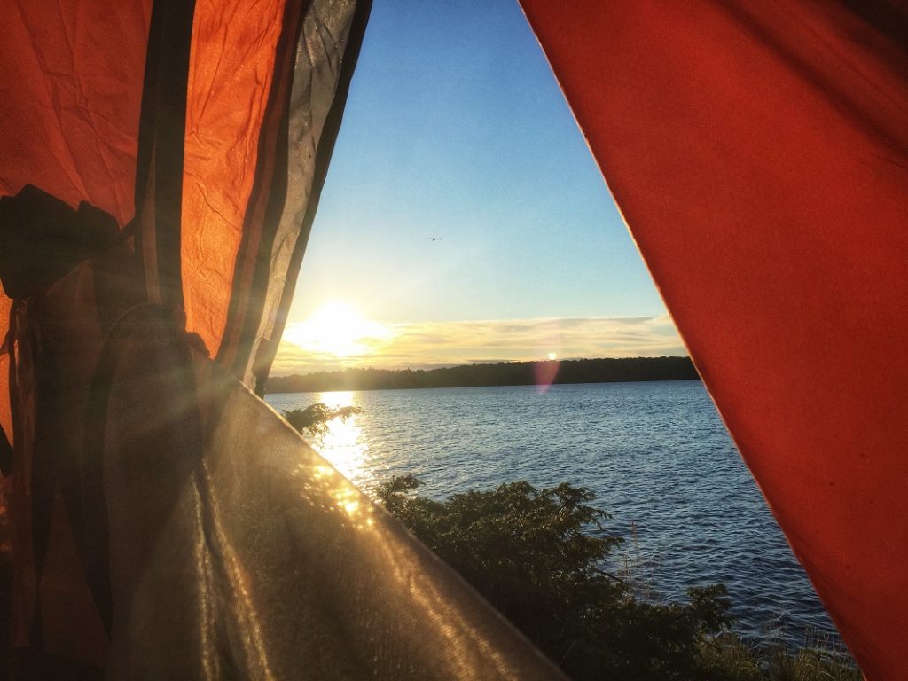 the view of a lake from within a tent