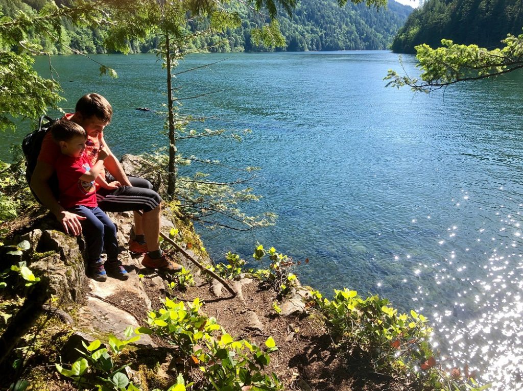 PerfectDayToPlay Sandy Cove Beach Trail at Harrison Hot Springs - back-trail, Alex and Cosmos sitting on a rock over stunning turquoise blue water 