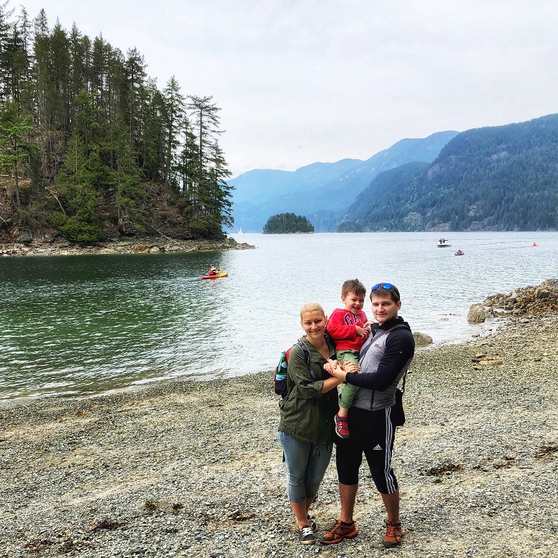 family posing for a photo at Jug Island Beach, Belcarra BC  with Indian Arm 