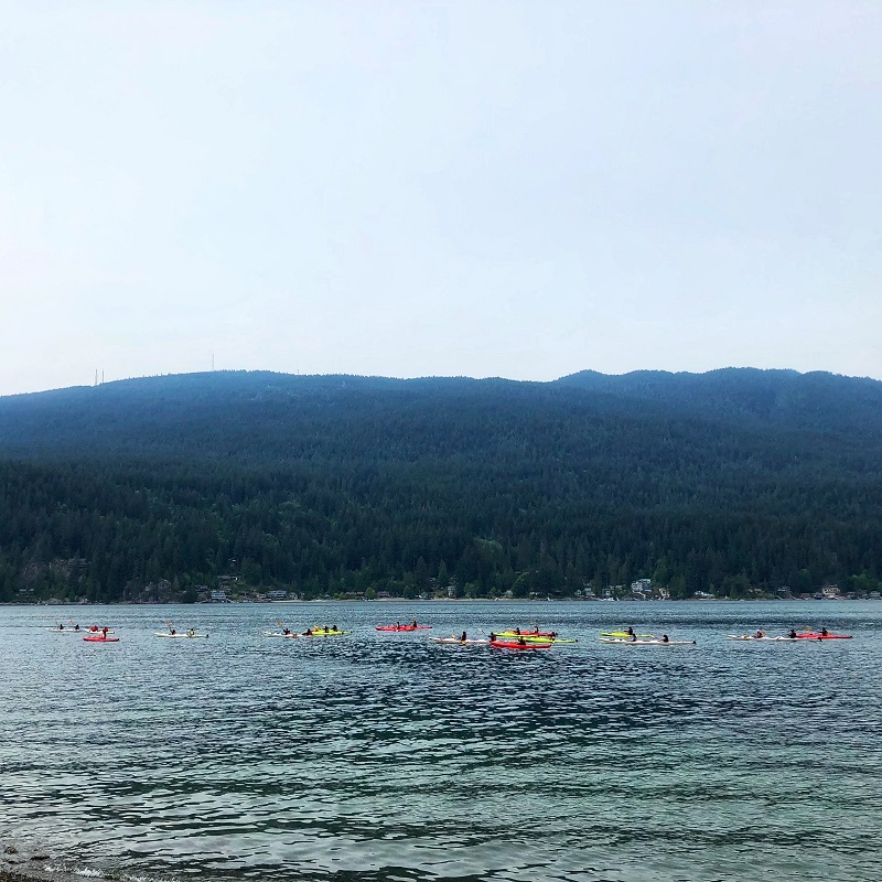 white, red and yellow kayaks swimming at Indian Arm inlet near Jug Island Beach