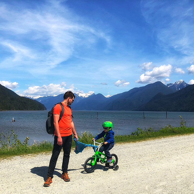 a father is towing his son's bike at Rannie Road in Pitt Lake Ecological Reserve, near Pitt Meadows, BC Grant Narrows Regional Park