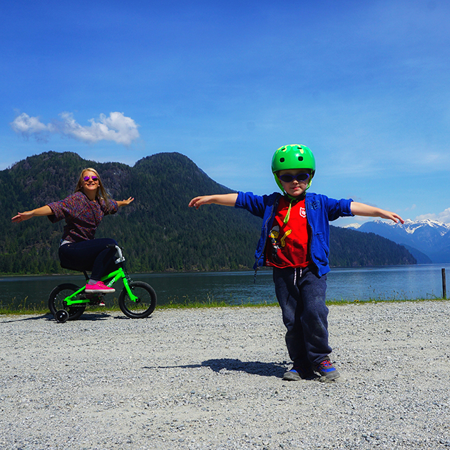 mother and son playing and riding a bike at Rannie Road in Pitt Lake Ecological Reserve, near Pitt Meadows, BC