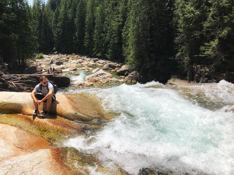 Alex is resting right next to the fierce waters of Gold Creek waterfall