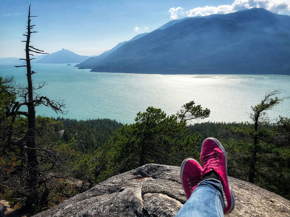 magenta sneakers and the view of Howe Sound as seen from Jurassic Ridge hiking trail in Murrin Provincial Park BC Canada next to Squamish in the summer