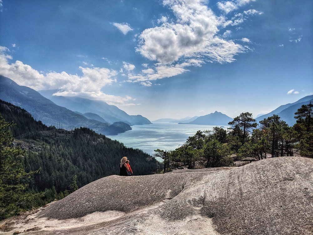 Mother and son view Howe Sound from Jurassic Ridge hiking trail in Murrin Provincial Park near Squamish in BC Canada