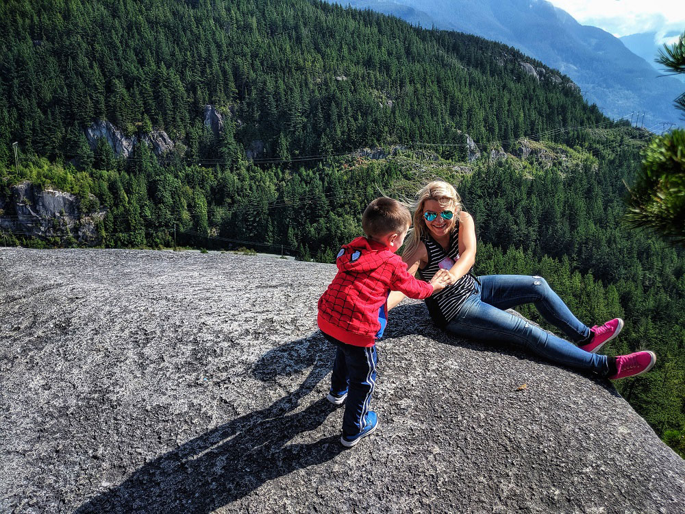 child helping mom to stand-up while hiking