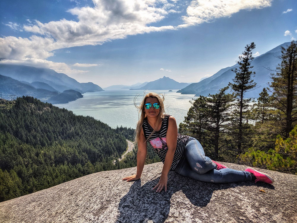 posing for a photo at the Howe Sound lookout in sunglasses - summer sun