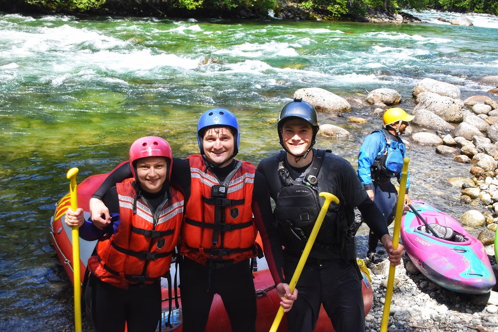 PerfectDayToPlay - two rafters and the instructor standing with paddles up on rafting experience completion