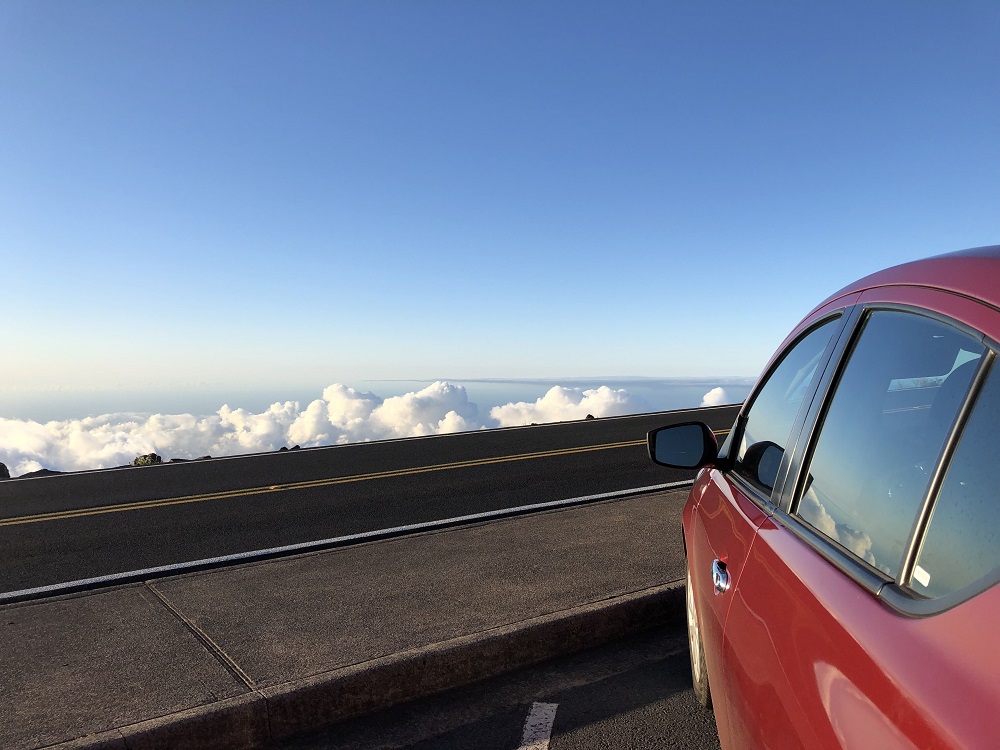 red car above the clouds on the road to Haleakala summit