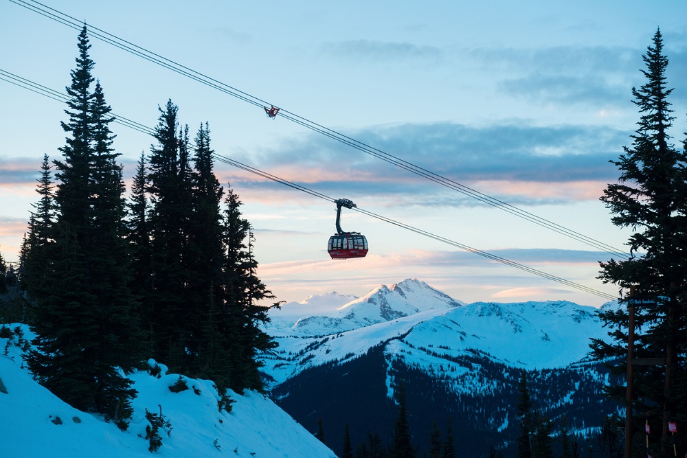 a ski lift in front of the mountains 