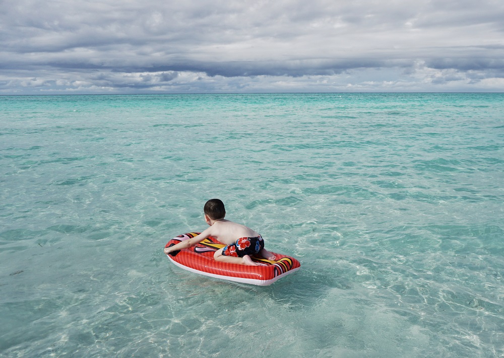 a child floating in the ocean on an inflatable boat