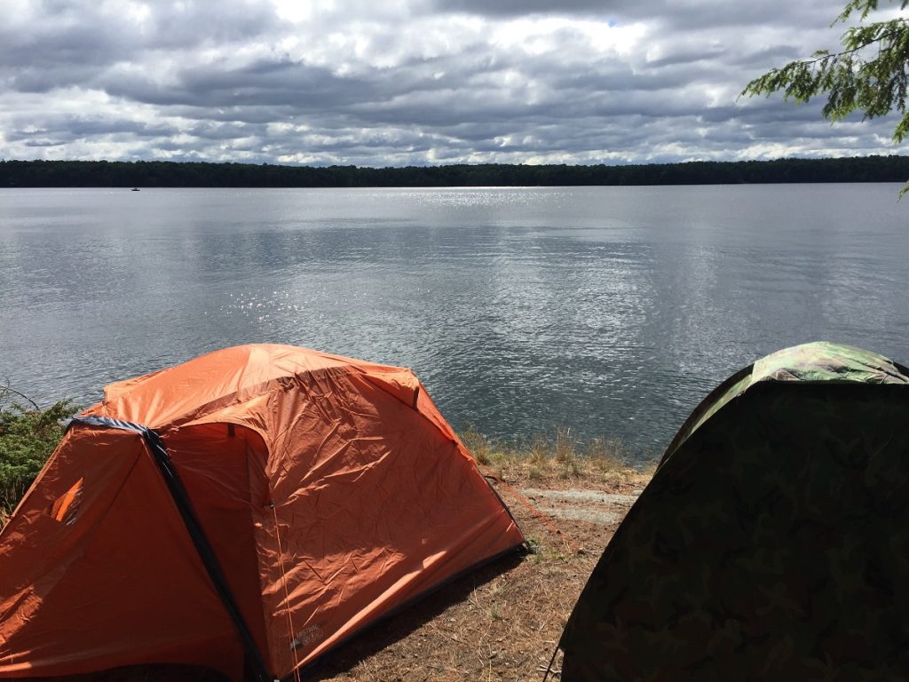 two tents near a lake. camp on durable surfaces