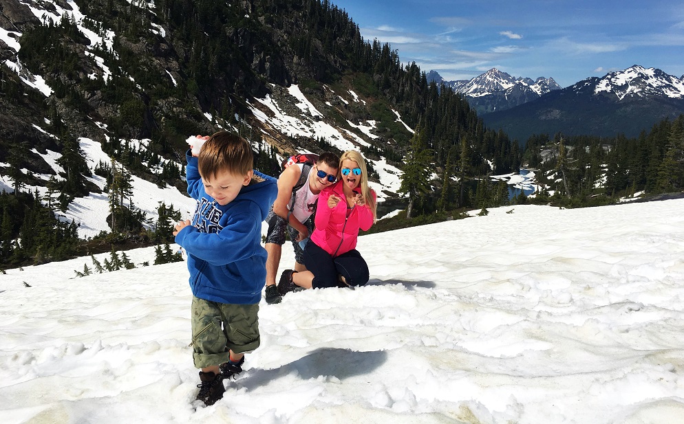 a family hiking and having fun in snow in the mountains