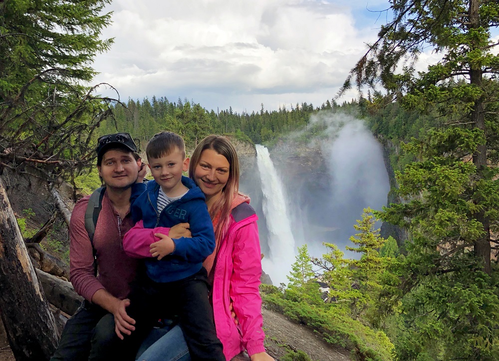 Family posing for a photo in front of Helmcken Falls on their Vancouver to Kamloops road-trip