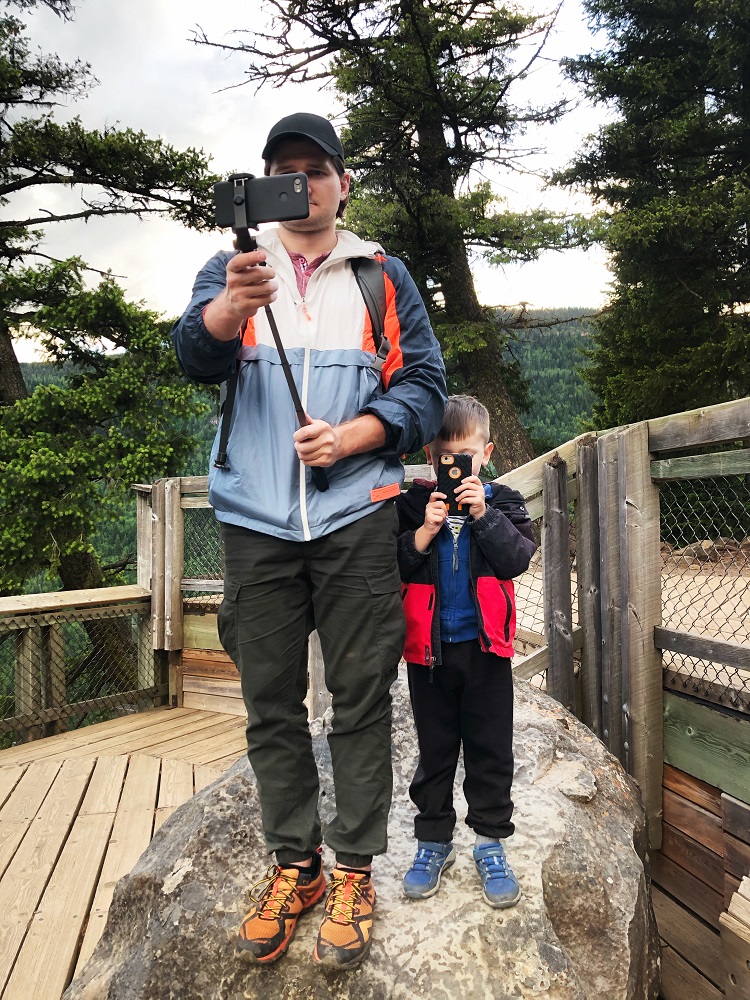 father and son taking photos with their phones