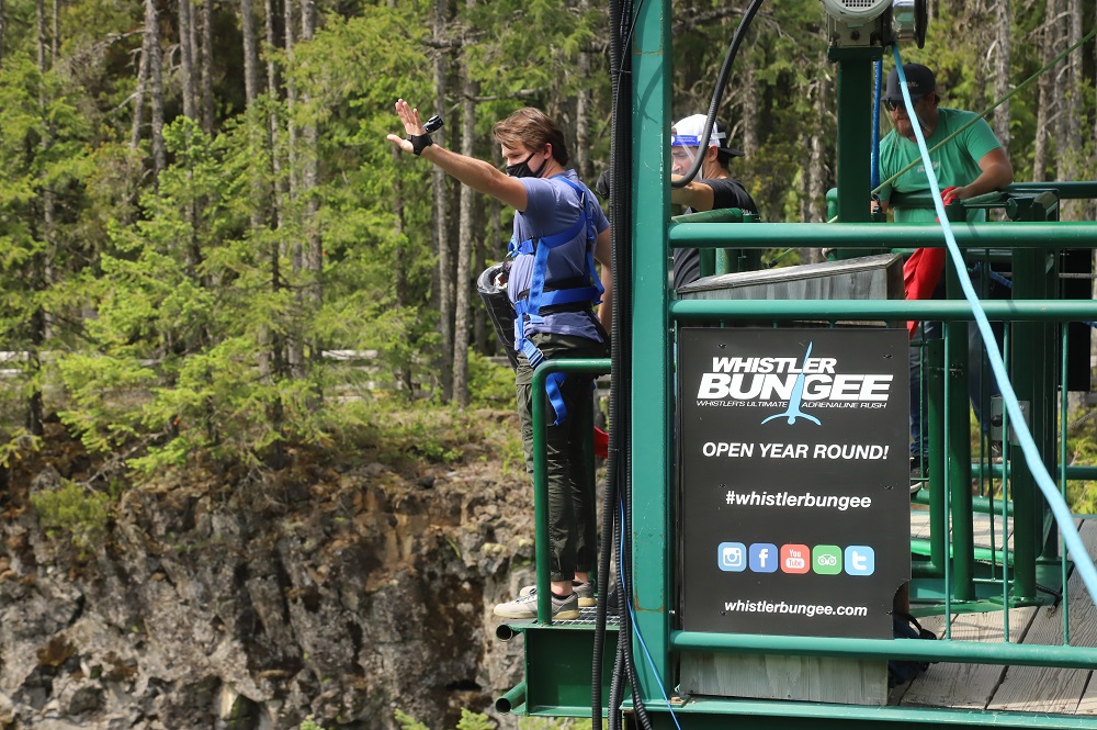 man in blue tshirt standing at Whistler bungee jumping bridge ready to jump