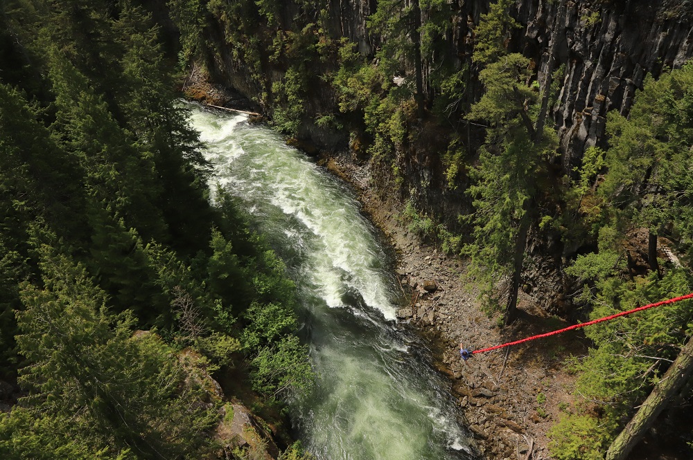 Cheakamus River as seen from Whistler Bungee bridge with a bungee jumper hanging over it