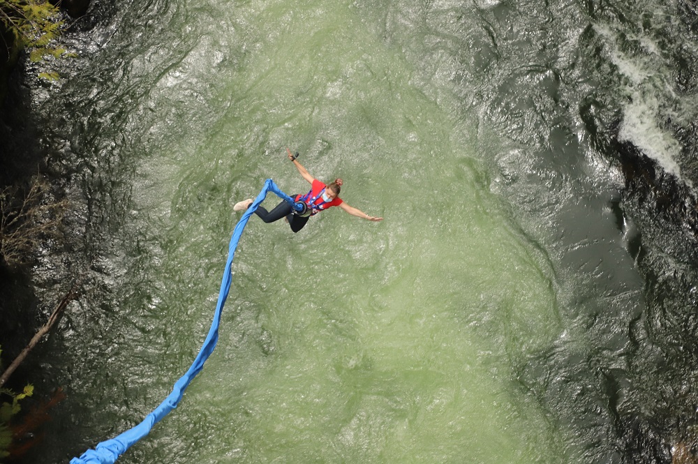 woman in red tshirt flying on bungee cord over the Cheakamus river