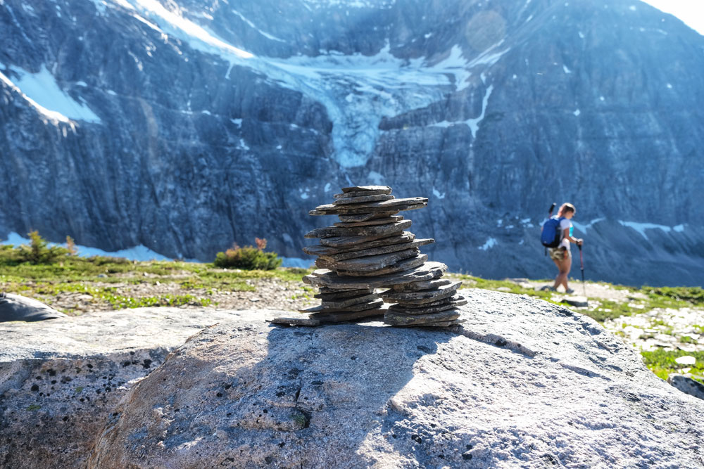 Inuksuk and the view of a glacier with a hiker at the back