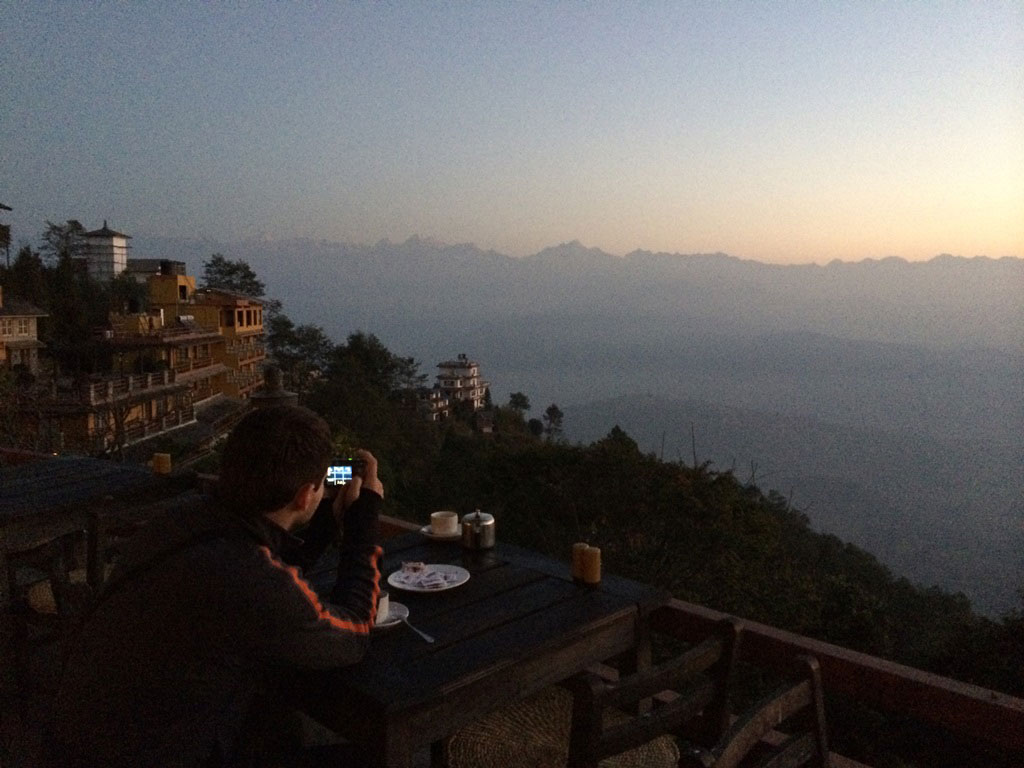 male tourist taking photos at an outdoor patio in a hotel in Nepal