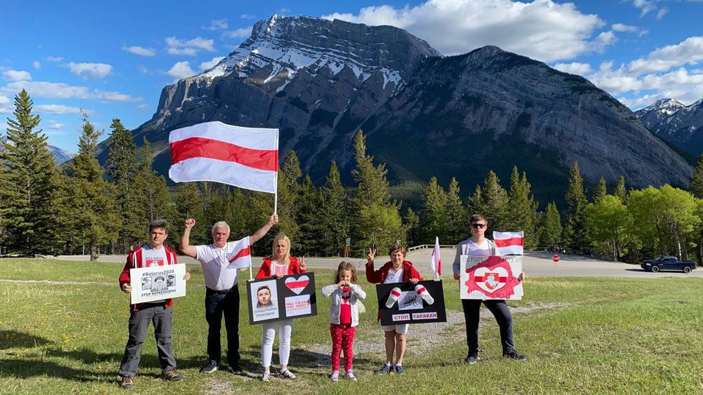 Alberta, Banff, Canada - family waving Belarus Freedom Flags