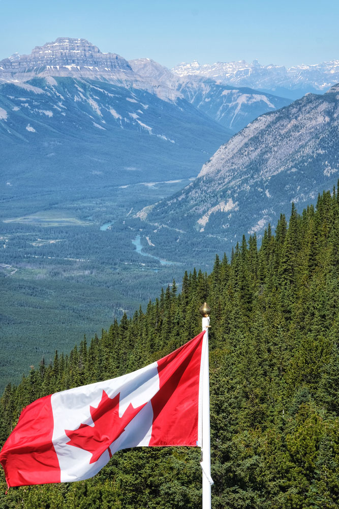 Canadian Flag and the valley with Canadian Rocky mountains